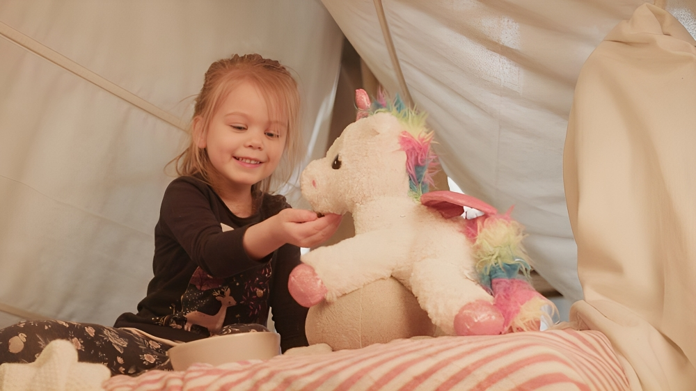 flicka leker med enhörning gosedjur